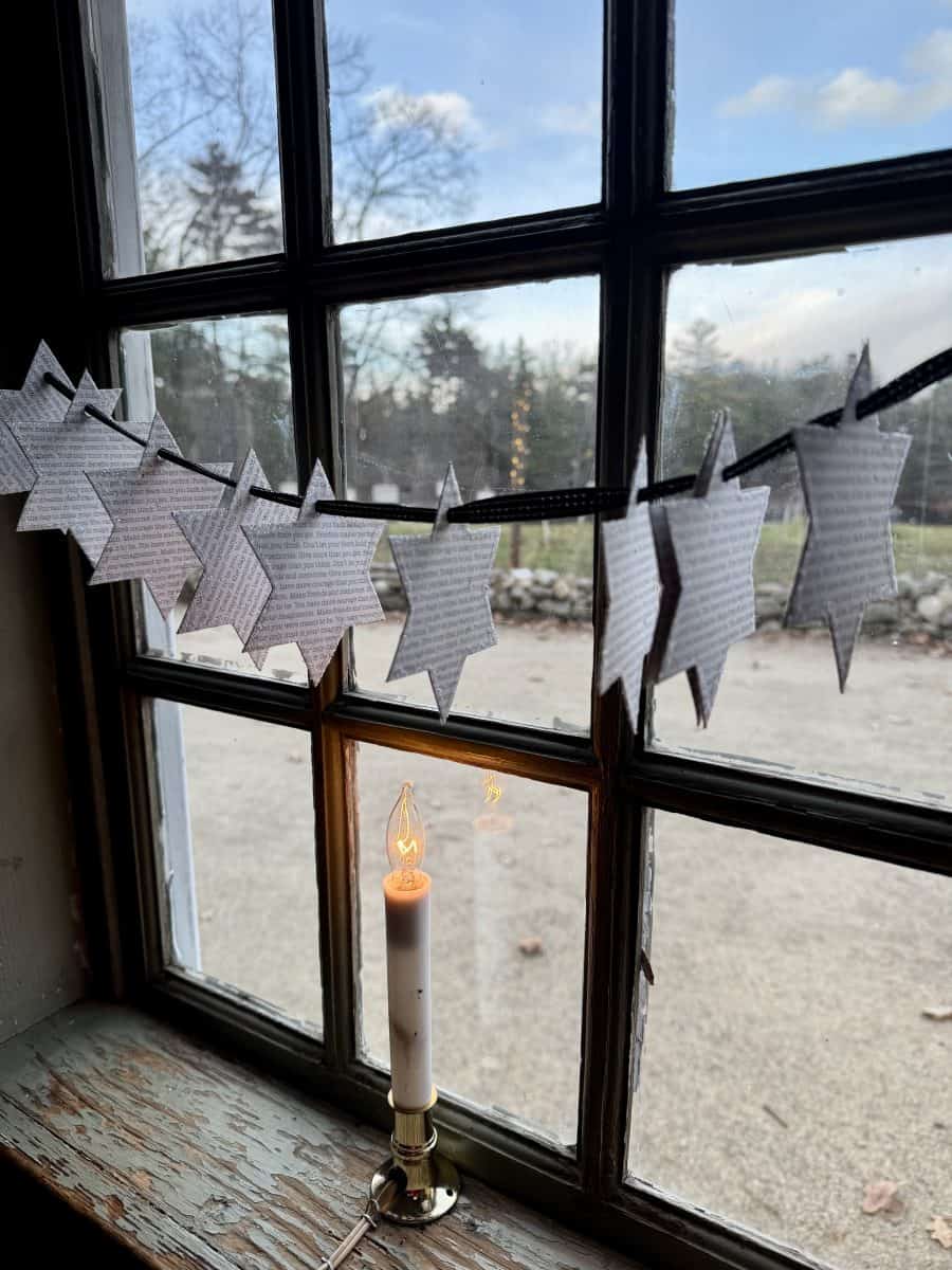 candlelit window decorated with stars at Christmas by Candlelight at Old Sturbridge Village in Sturbridge, MA