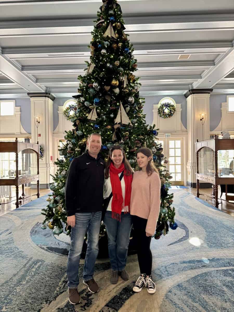 family in front of Christmas tree at Disney's Yacht Club resort