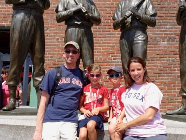 family outside Fenway Park in Boston wearing Red Sox shirts