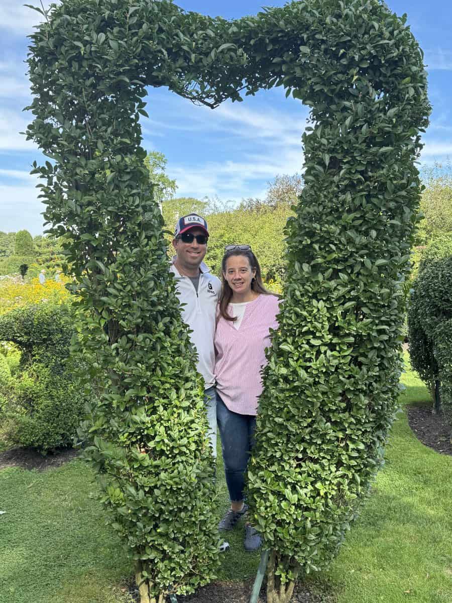 standing behind the heart topiary at the Green Animals Topiary Garden in Portsmouth RI